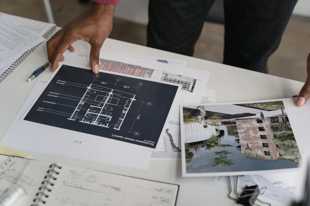 Hands analyzing architectural drawings and project calculations