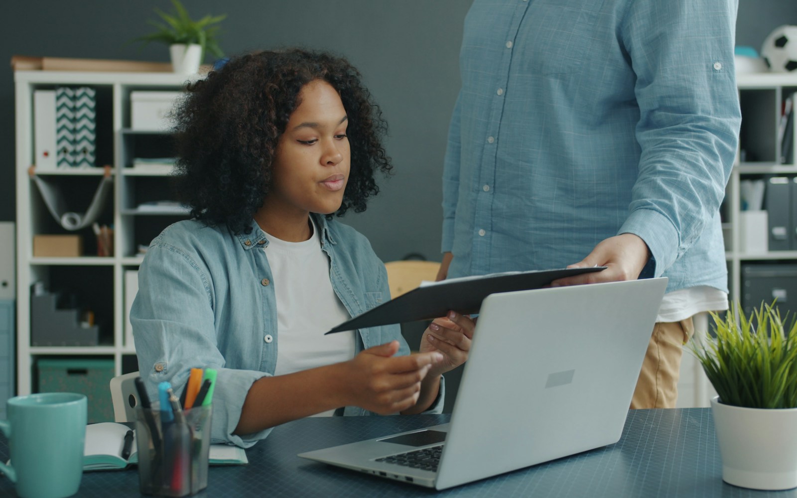 Insurance professionals reviewing business documents beside a laptop
