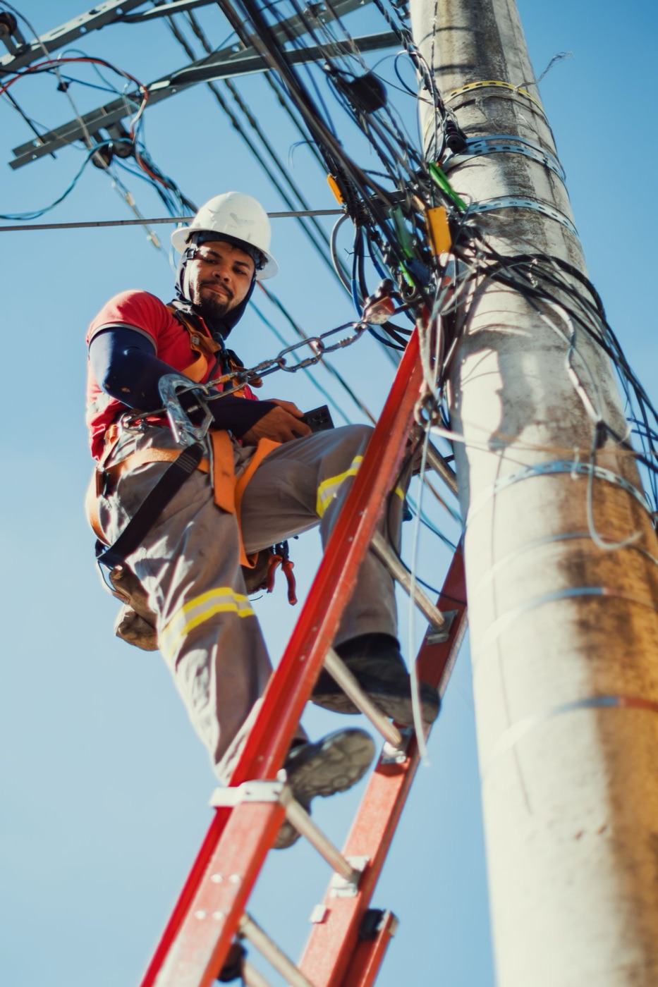Telecom field technician servicing network equipment on a utility pole